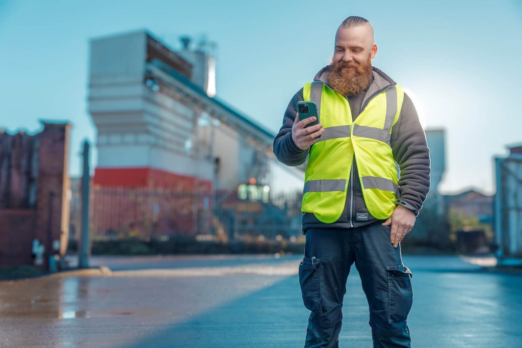 Man holding mobile phone wearing hi-vis vest